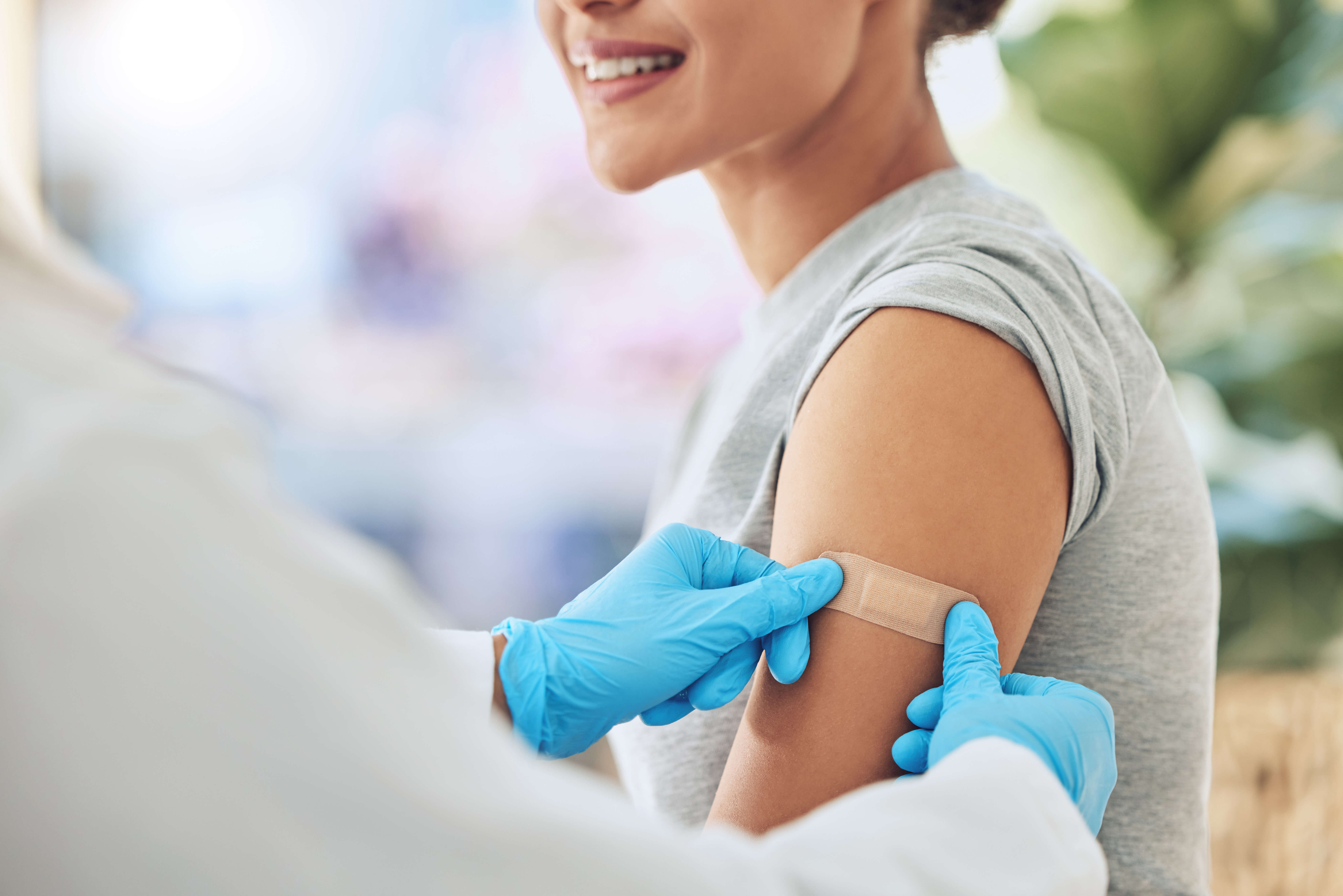 femme qui vient de se faire vacciner par un médecin en blouse blanche