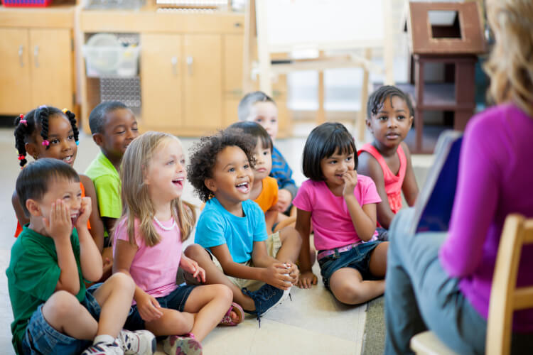 enfants assis devant professeur d'école