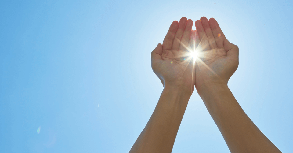 mains tendues dans le ciel bleu vers le soleil