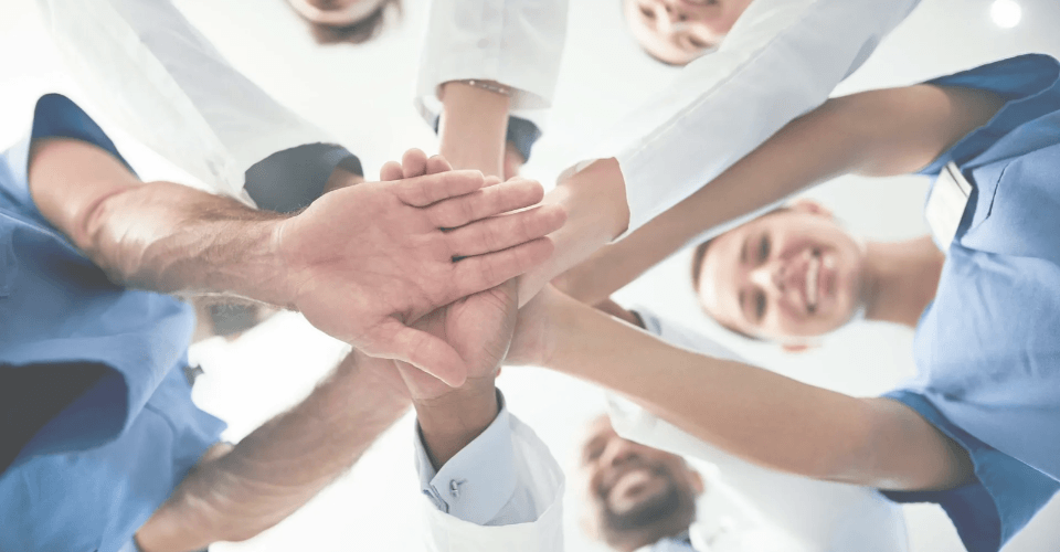 infirmier et médecin qui travaillent ensemble et joignent leur main 