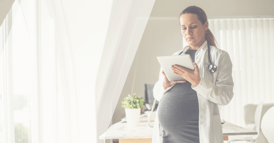 Médecin enceinte en blouse blanche qui travaille