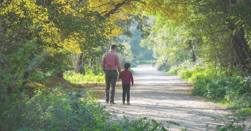 un père et son fils qui marchent dans la forêt