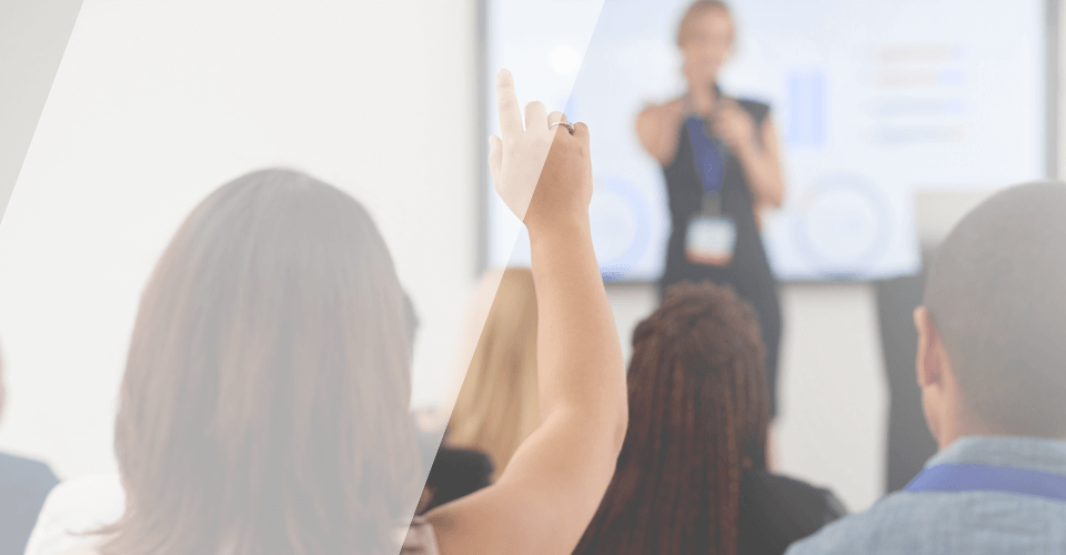 séance d'information avec une personne du public qui lève la main pour poser une question