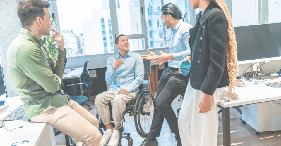 des collègues de travail qui discutent dont une personne en chaise roulante