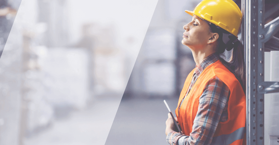 femme portant un casque et un gilet de chantier qui soupire, signes de fatigue