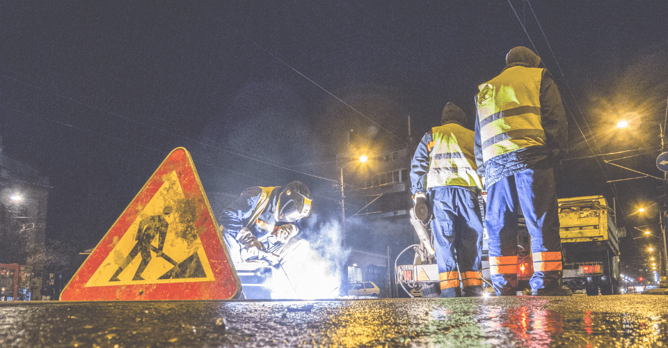 ouvrier de la route travaillant de nuit sur un chantier, un panneau de chantier