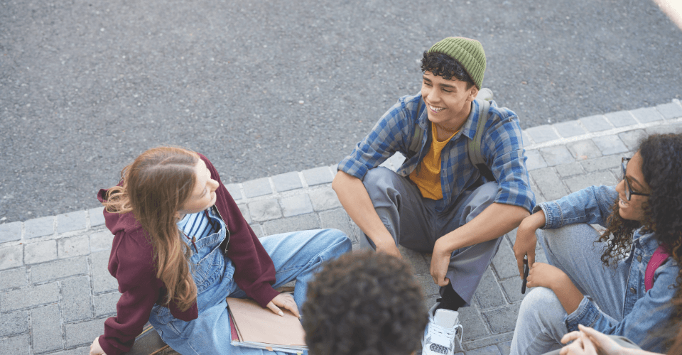 groupe de jeunes adolescents qui discutent assis en cercle sur le sol