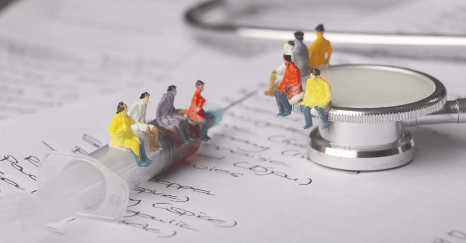 figurines de médecins sur un stéthoscope et une seringue