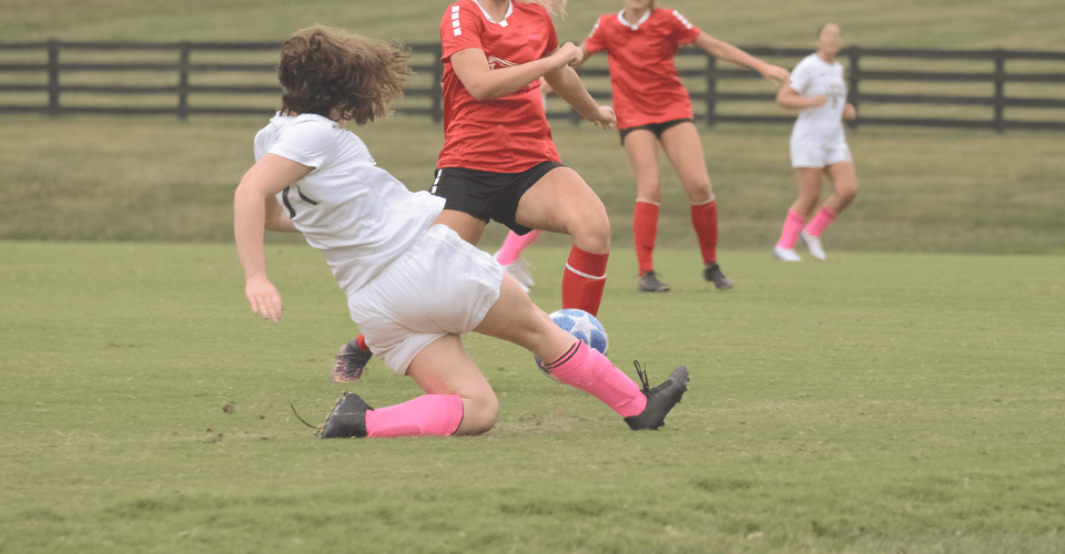 une fille sportive qui fait du football sur un terrain 